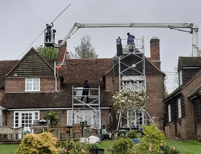 The Moss Cleaners using cherry picker and scaffolding to clean roof safely and professionally in Kings Worthy, Hampshire